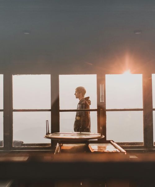 Silhouette of a man standing still, looking thoughtful.